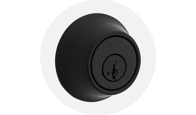 Kwikset Residential Deadbolt in matte black finish product isolated on top of a gray circle